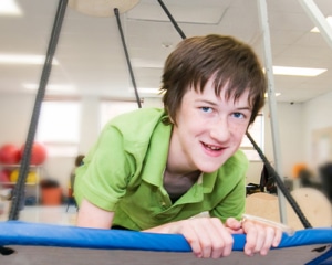 An image capturing a joyful moment during occupational therapy, where the swing is part of a therapeutic session designed to enhance sensory integration, motor skills, and overall well-being.
